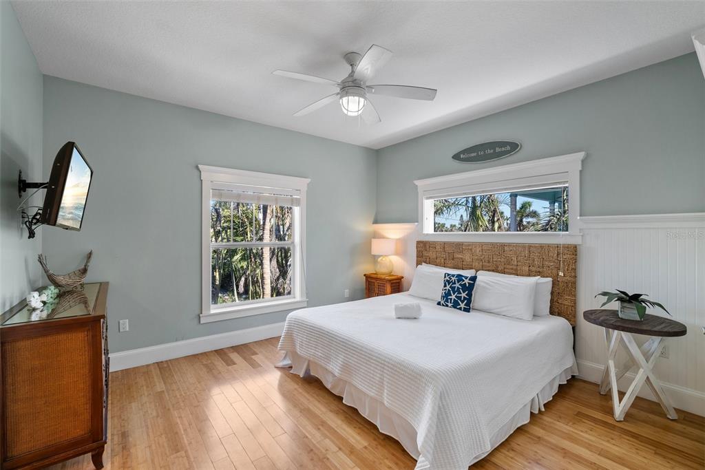 204 66th Street Holmes Beach, FL 34217 - Photo 23 of 53 a bedroom with a bed and a flat tv screen on the dresser
