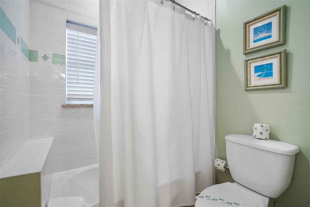 204 66th Street Holmes Beach, FL 34217 - Photo 25 of 53 a bathroom with a toilet and a shower curtain