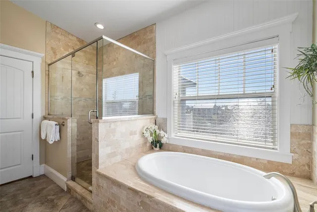 a spacious bedroom with a bed a chandelier and large window