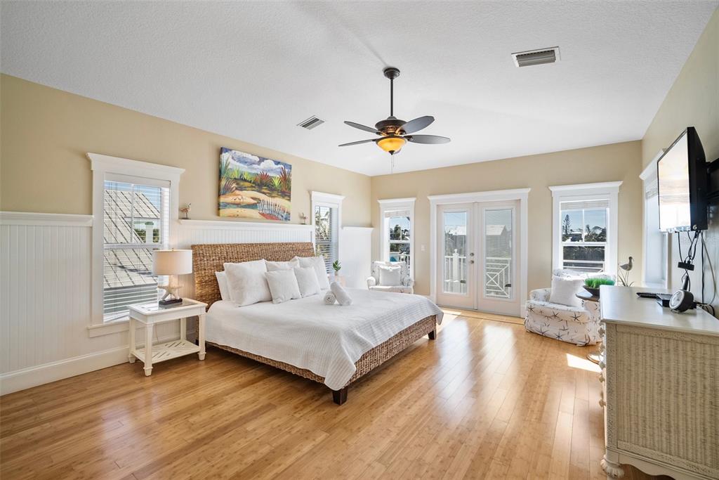 204 66th Street Holmes Beach, FL 34217 - Photo 36 of 53 a spacious bedroom with a bed a chandelier and large window