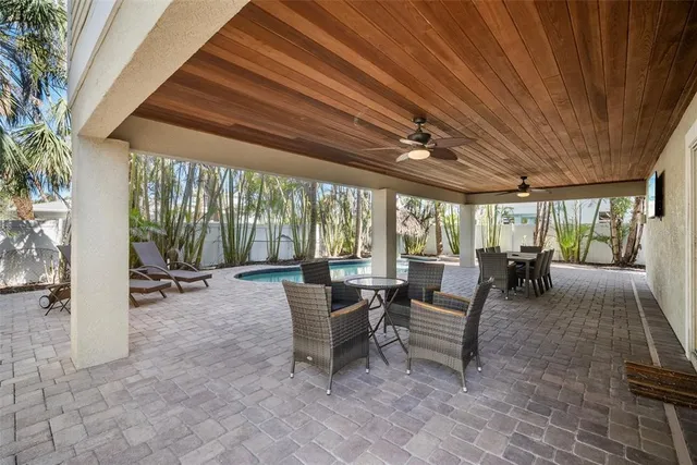 a view of a patio with table and chairs with wooden floor and fence