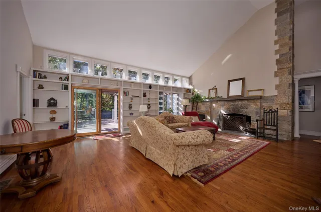 a dining room with wooden floor a chandelier a wooden table and chairs