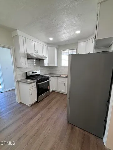 a kitchen with stainless steel appliances a refrigerator sink and microwave