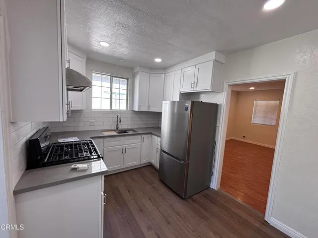 a kitchen with a refrigerator a sink and cabinets