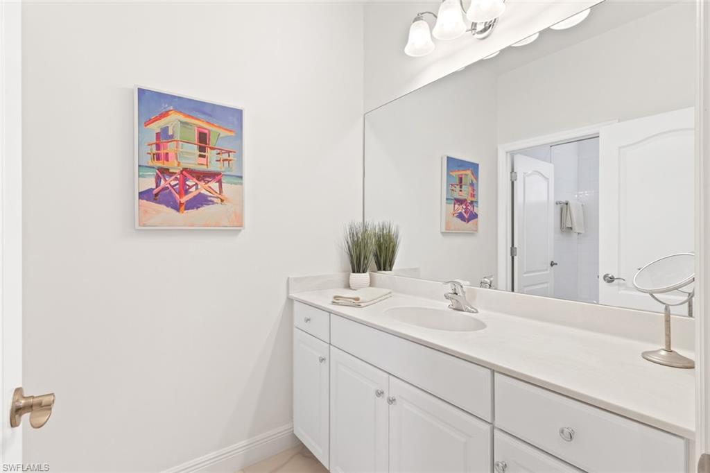 6973 Avalon Circle, Unit 1406 Naples, FL 34112 - Photo 18 of 36 Bathroom featuring vanity and baseboards