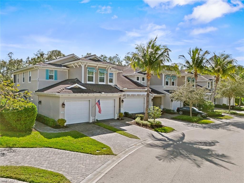 6973 Avalon Circle, Unit 1406 Naples, FL 34112 - Photo 2 of 36 View of front of home with decorative driveway, a garage, a tile roof, and stucco siding