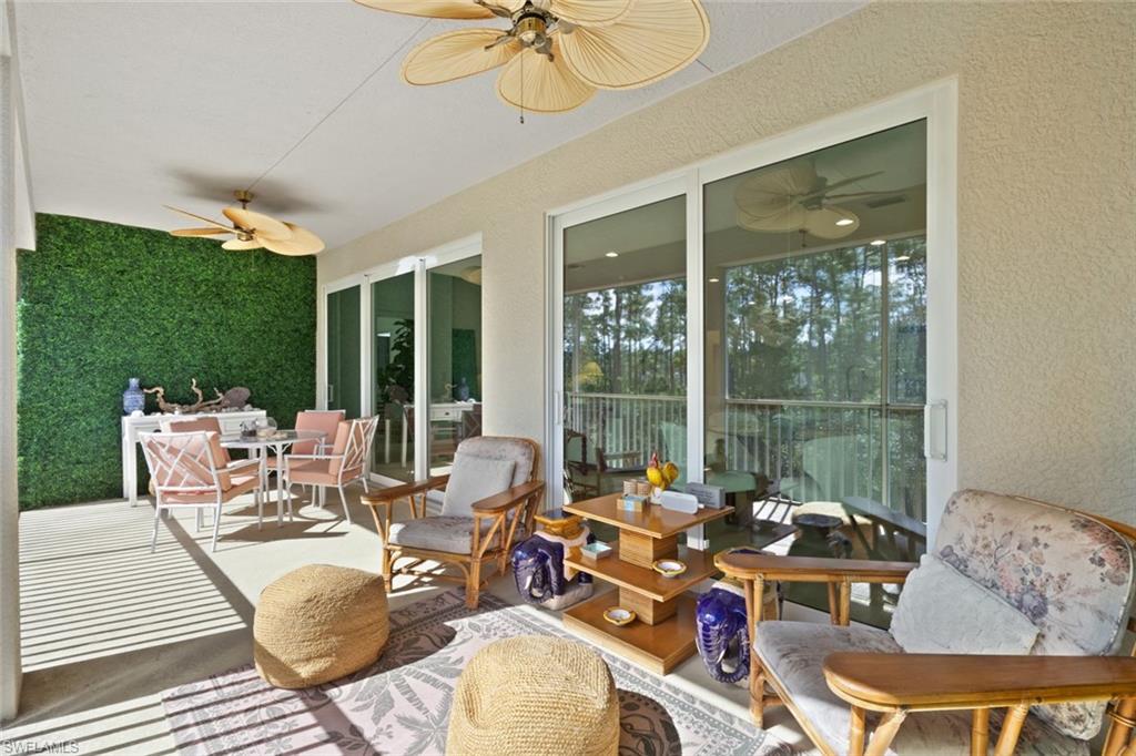 6973 Avalon Circle, Unit 1406 Naples, FL 34112 - Photo 22 of 36 Sunroom featuring outdoor dining area, ceiling fan, and a patio