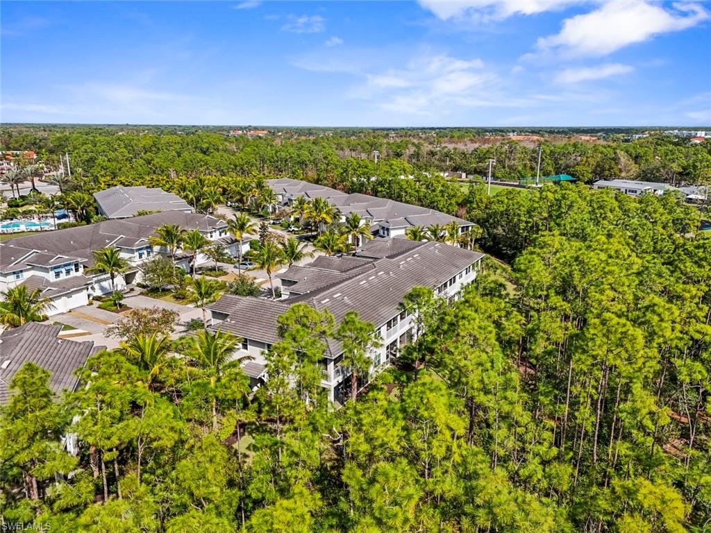 6973 Avalon Circle, Unit 1406 Naples, FL 34112 - Photo 27 of 36 Aerial view of a tree filled landscape