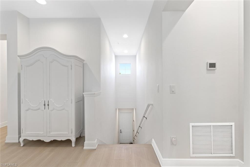 6973 Avalon Circle, Unit 1406 Naples, FL 34112 - Photo 5 of 36 Hallway featuring an upstairs landing, light wood-style flooring, and recessed lighting