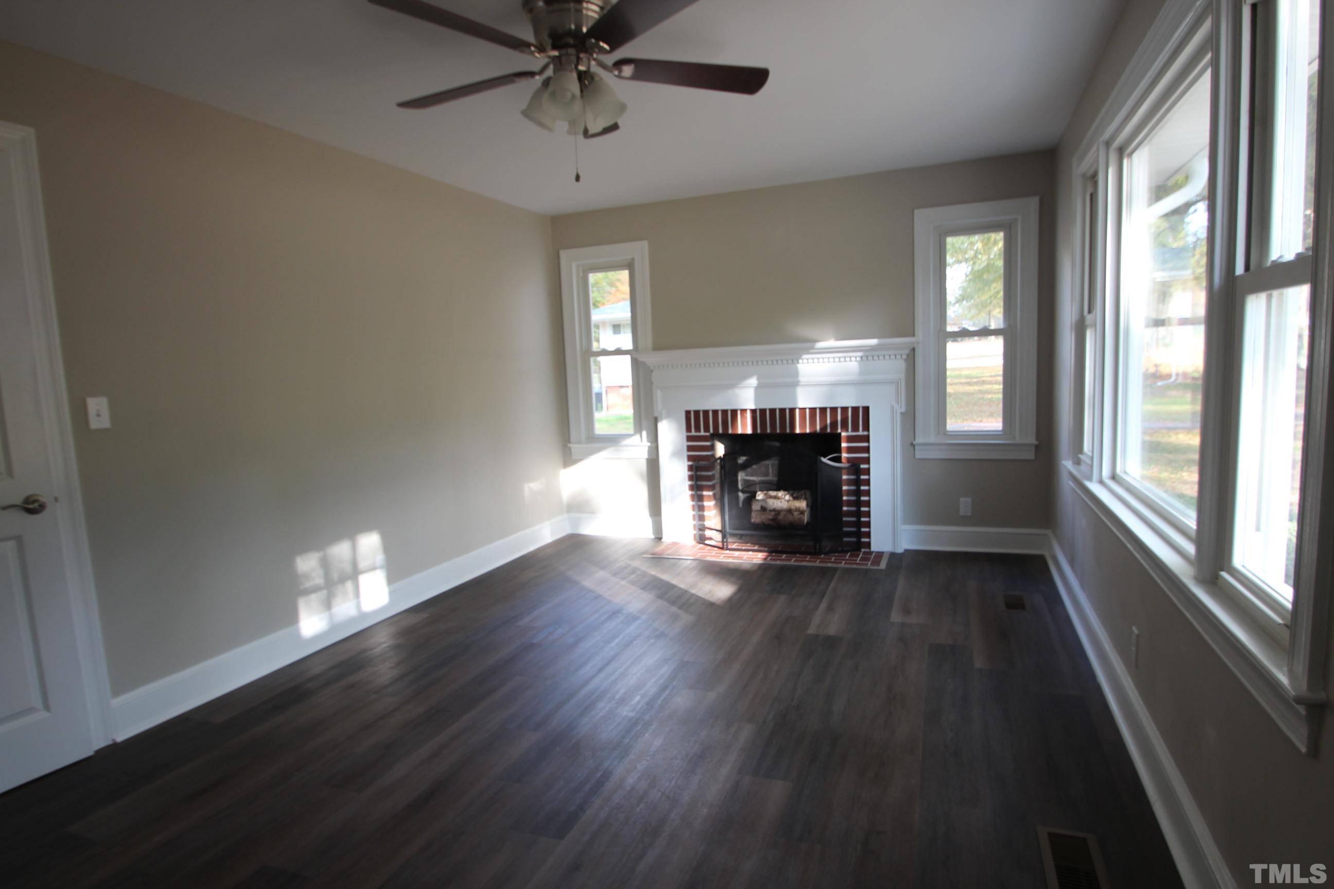 895 Oxford Road Roxboro, NC 27574 - Photo 13 of 23 a view of empty room with fireplace and wooden floor