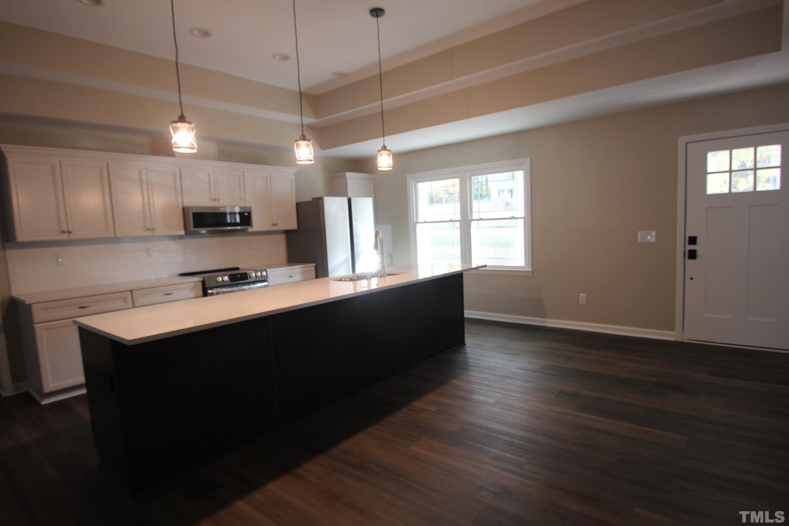 895 Oxford Road Roxboro, NC 27574 - Photo 16 of 23 a kitchen with stainless steel appliances granite countertop a sink a stove a refrigerator cabinets and wooden floor