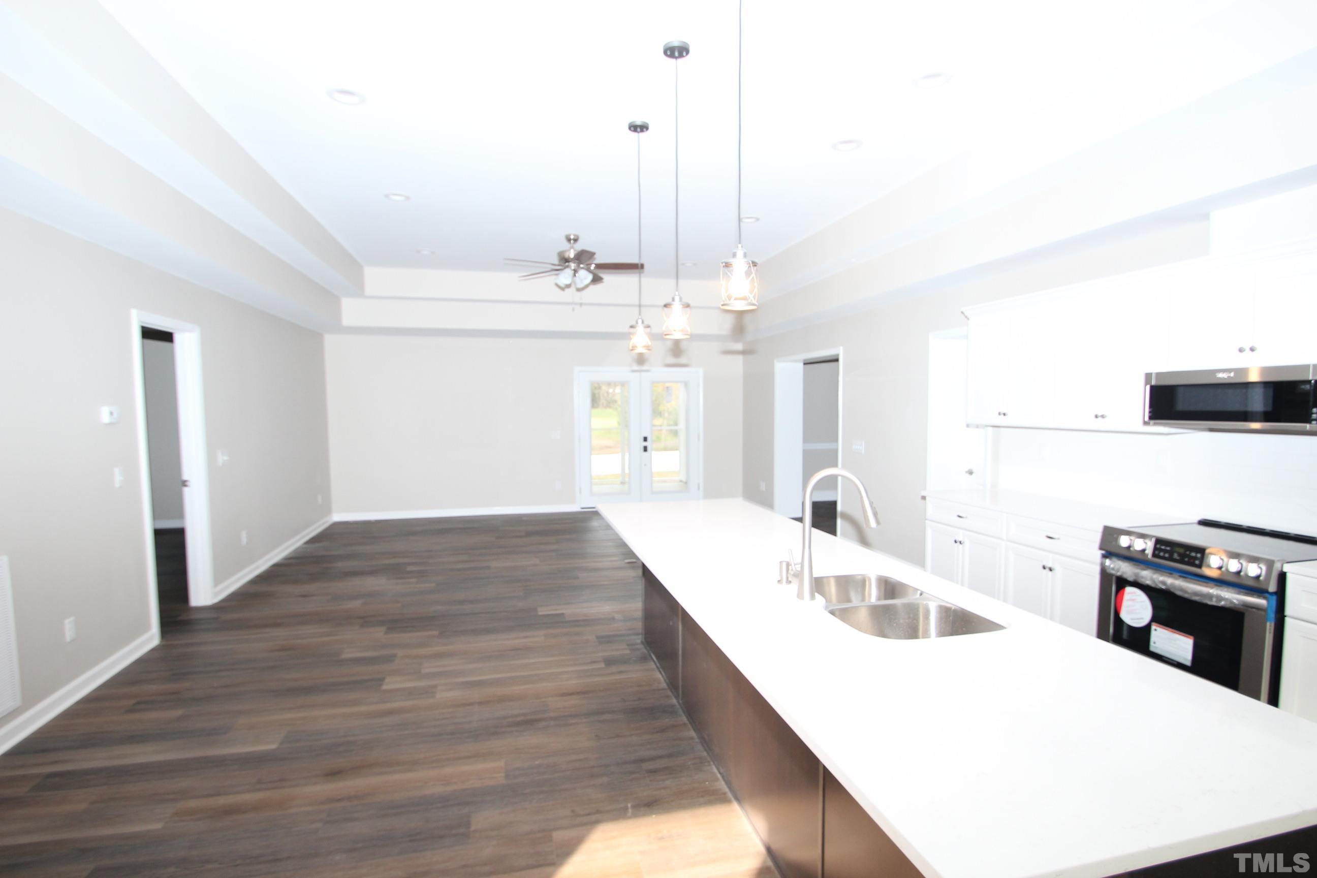 895 Oxford Road Roxboro, NC 27574 - Photo 5 of 23 a kitchen with kitchen island a stove a sink and a refrigerator
