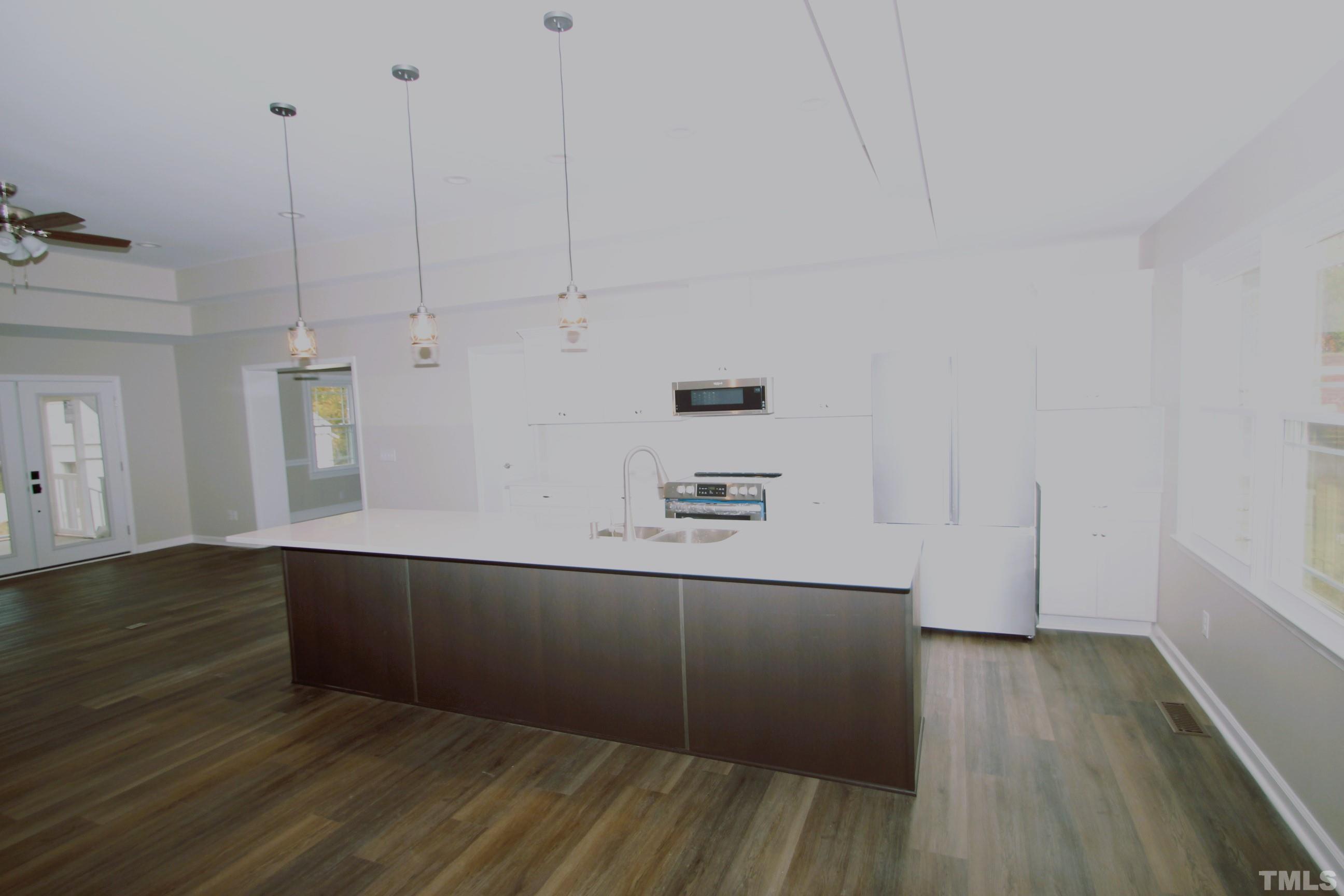 895 Oxford Road Roxboro, NC 27574 - Photo 6 of 23 a kitchen with cabinets and wooden floor
