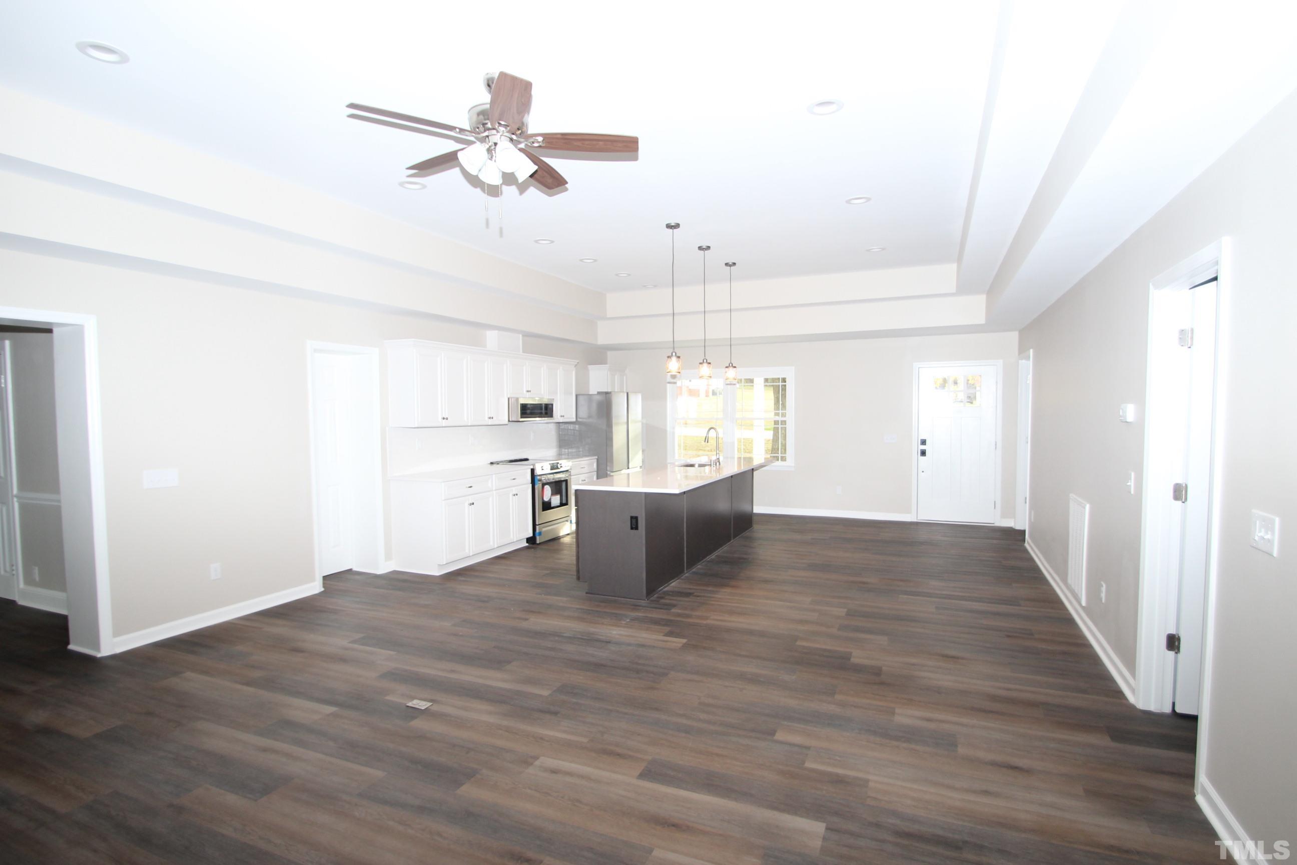 895 Oxford Road Roxboro, NC 27574 - Photo 7 of 23 a view of an empty room and kitchen with wooden floor