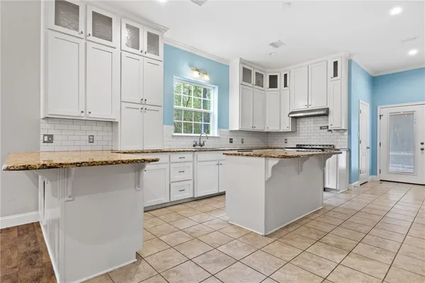 a kitchen with stainless steel appliances granite countertop a stove a sink and a refrigerator