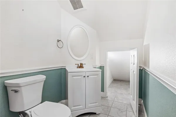 a bathroom with a toilet a sink and a mirror