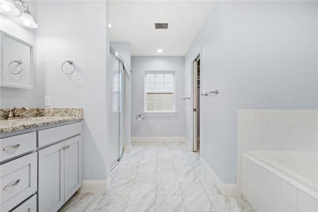 275 Woodruff Road Waco, TX 76705 - Photo 23 of 42 a bathroom with a granite countertop sink a mirror and a bathtub