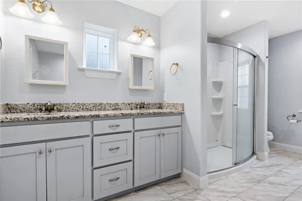 a bathroom with a granite countertop sink a mirror and a shower