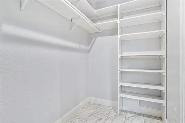 a view of walk in closet with empty racks