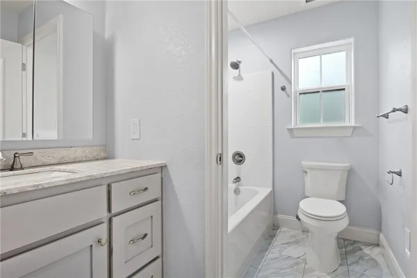 a bathroom with a granite countertop sink toilet a mirror and shower