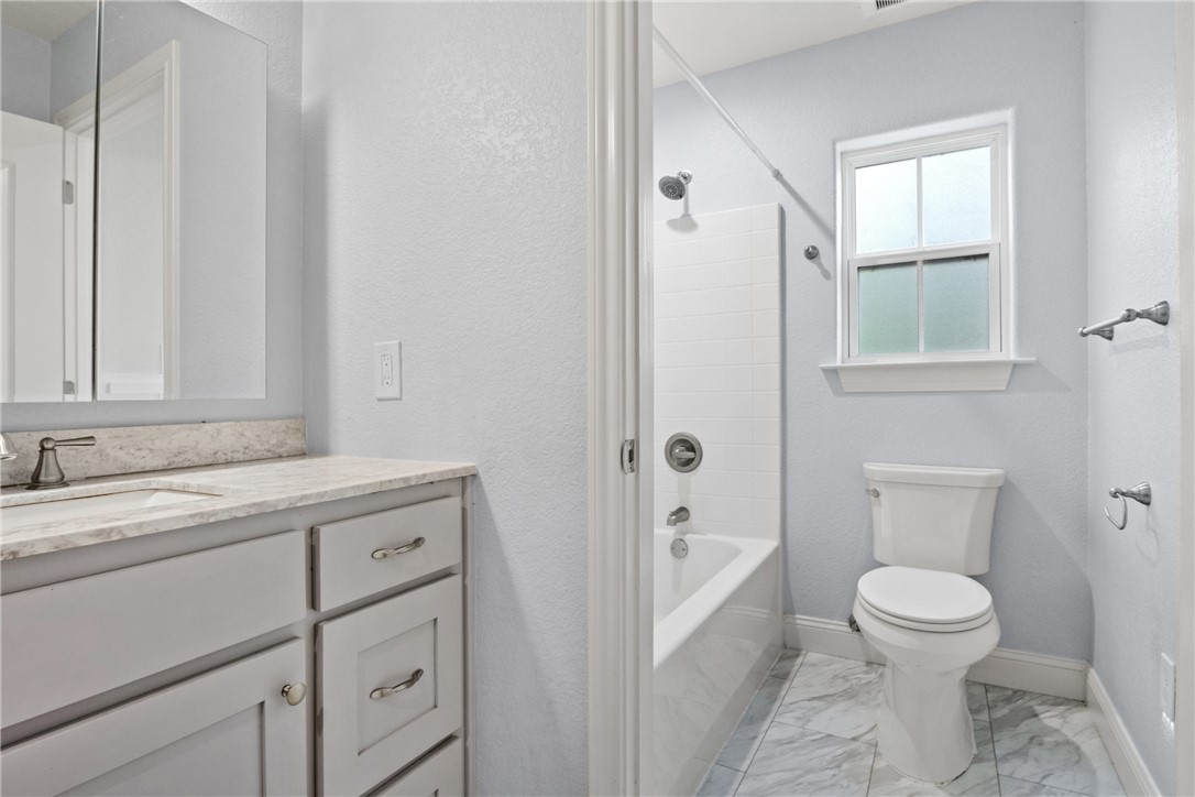 275 Woodruff Road Waco, TX 76705 - Photo 35 of 42 a bathroom with a granite countertop sink toilet a mirror and shower