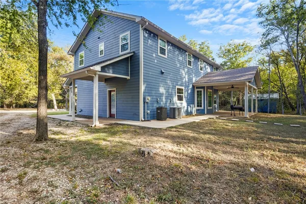 a view of a house with backyard and a tree