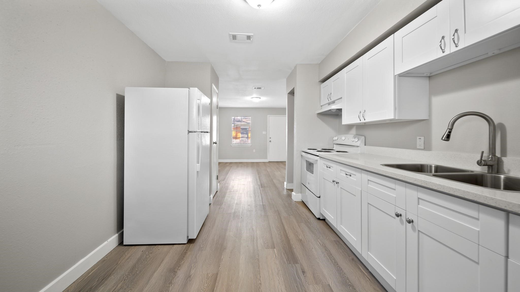 7810 Glass Street Houston, TX 77016 - Photo 5 of 12 a kitchen with stainless steel appliances a refrigerator sink and cabinets