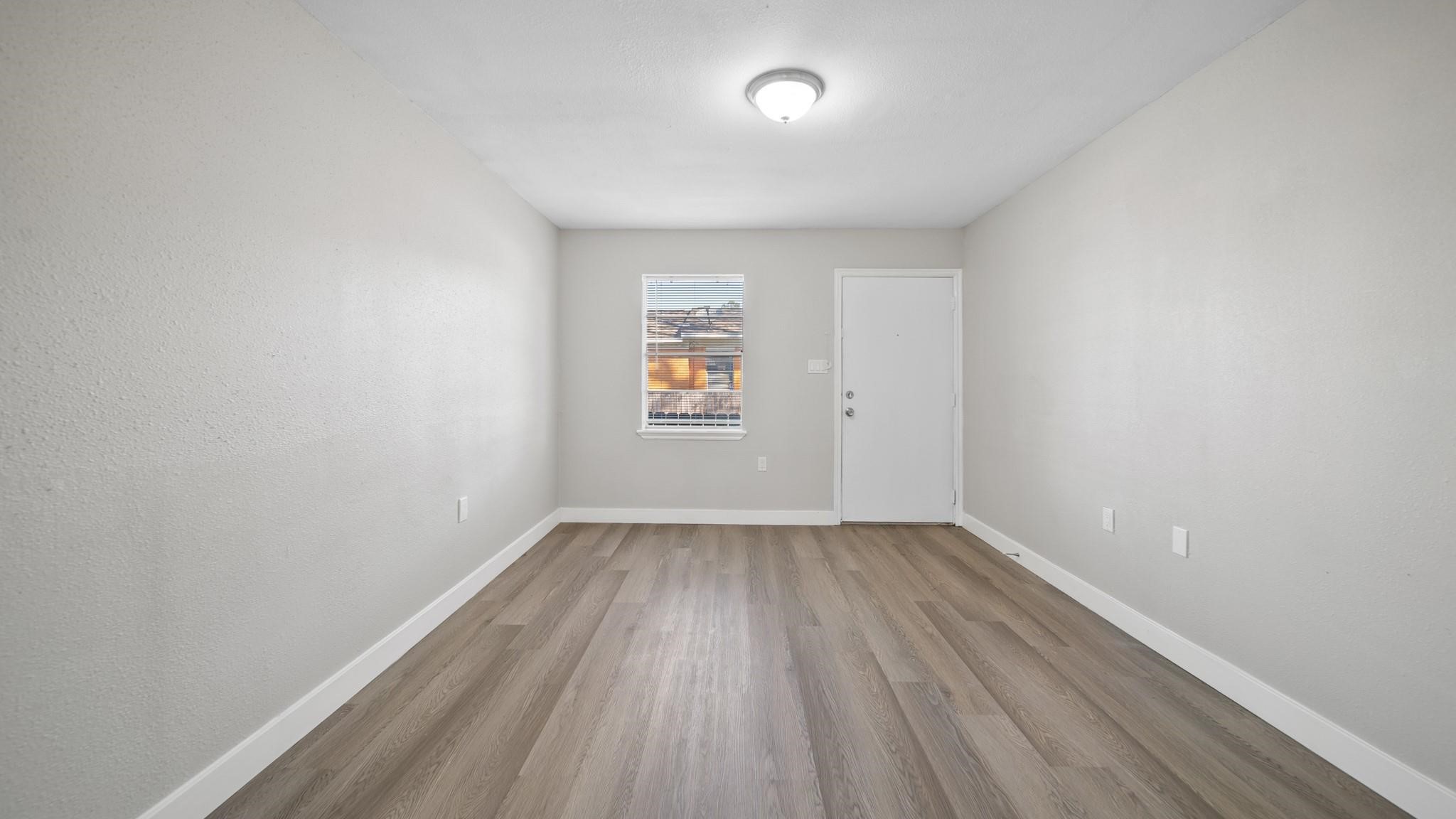 7810 Glass Street Houston, TX 77016 - Photo 6 of 12 wooden floor in an empty room with a window