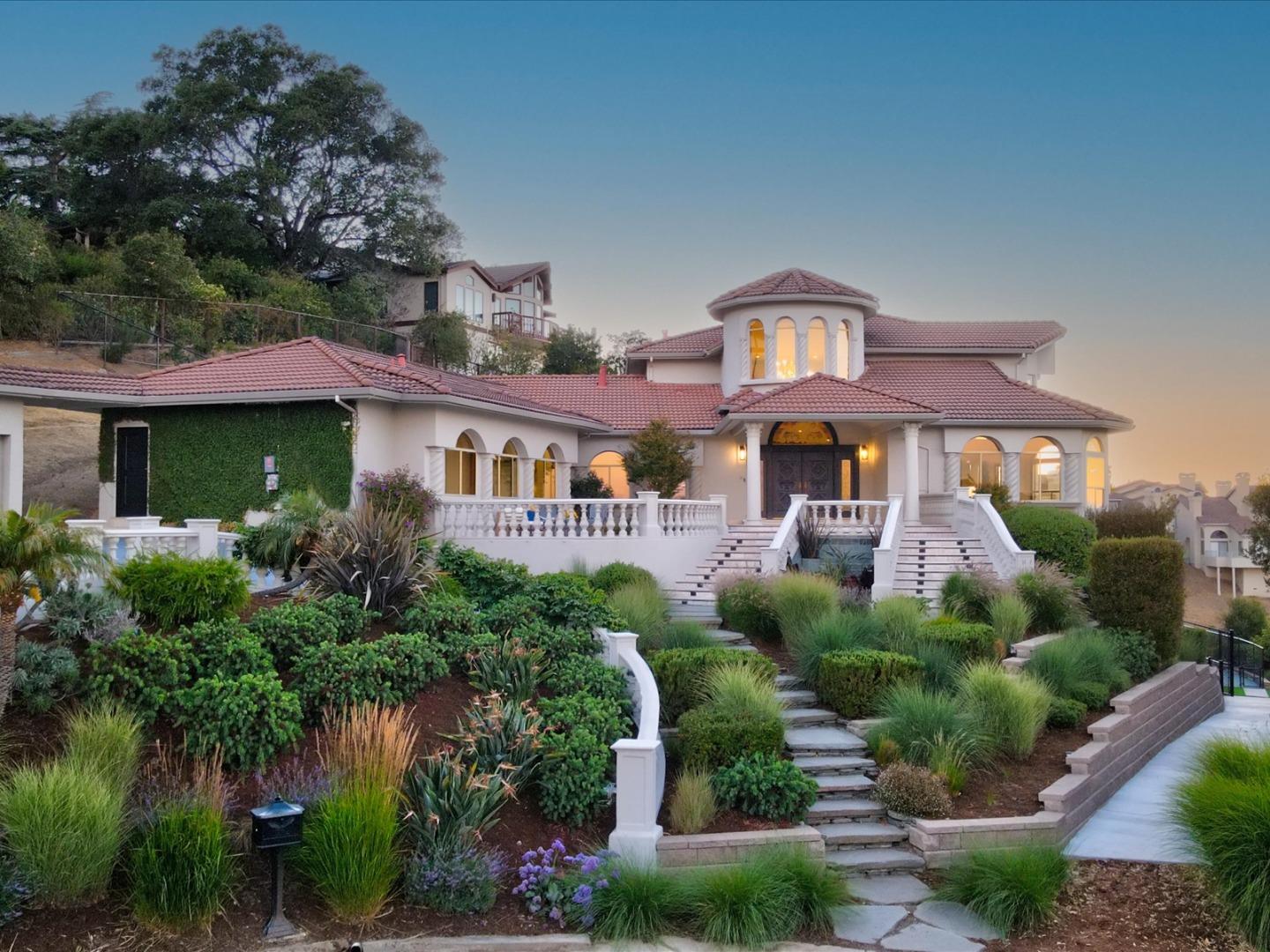 a front view of a house with a yard and potted plants