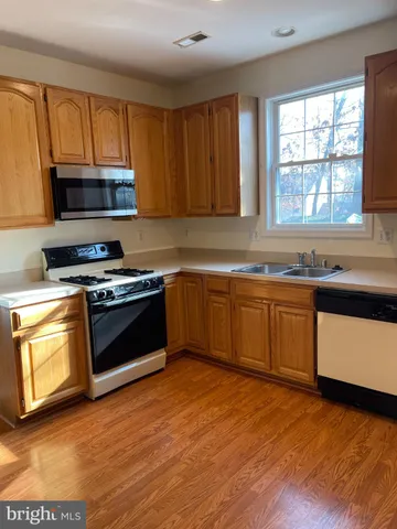 a kitchen with stainless steel appliances granite countertop a refrigerator and a stove