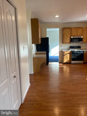 a view of a kitchen with a stove wooden floor and a kitchen space
