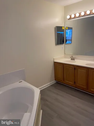 a view of walk in closet with wooden floor