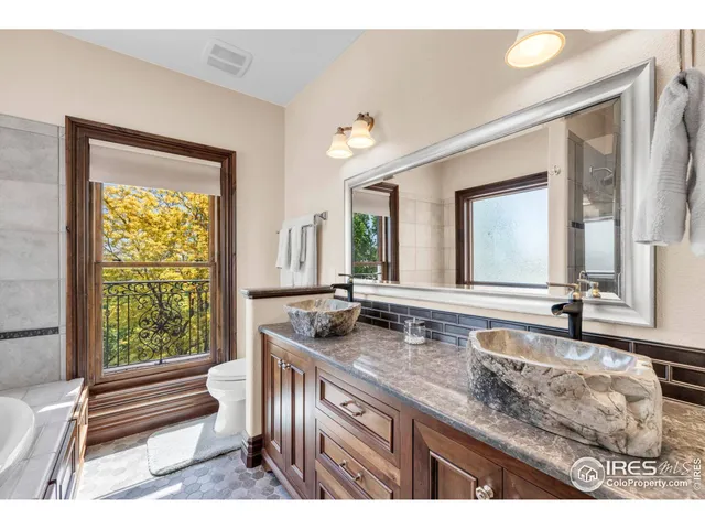 a bathroom with a granite countertop sink and a large mirror