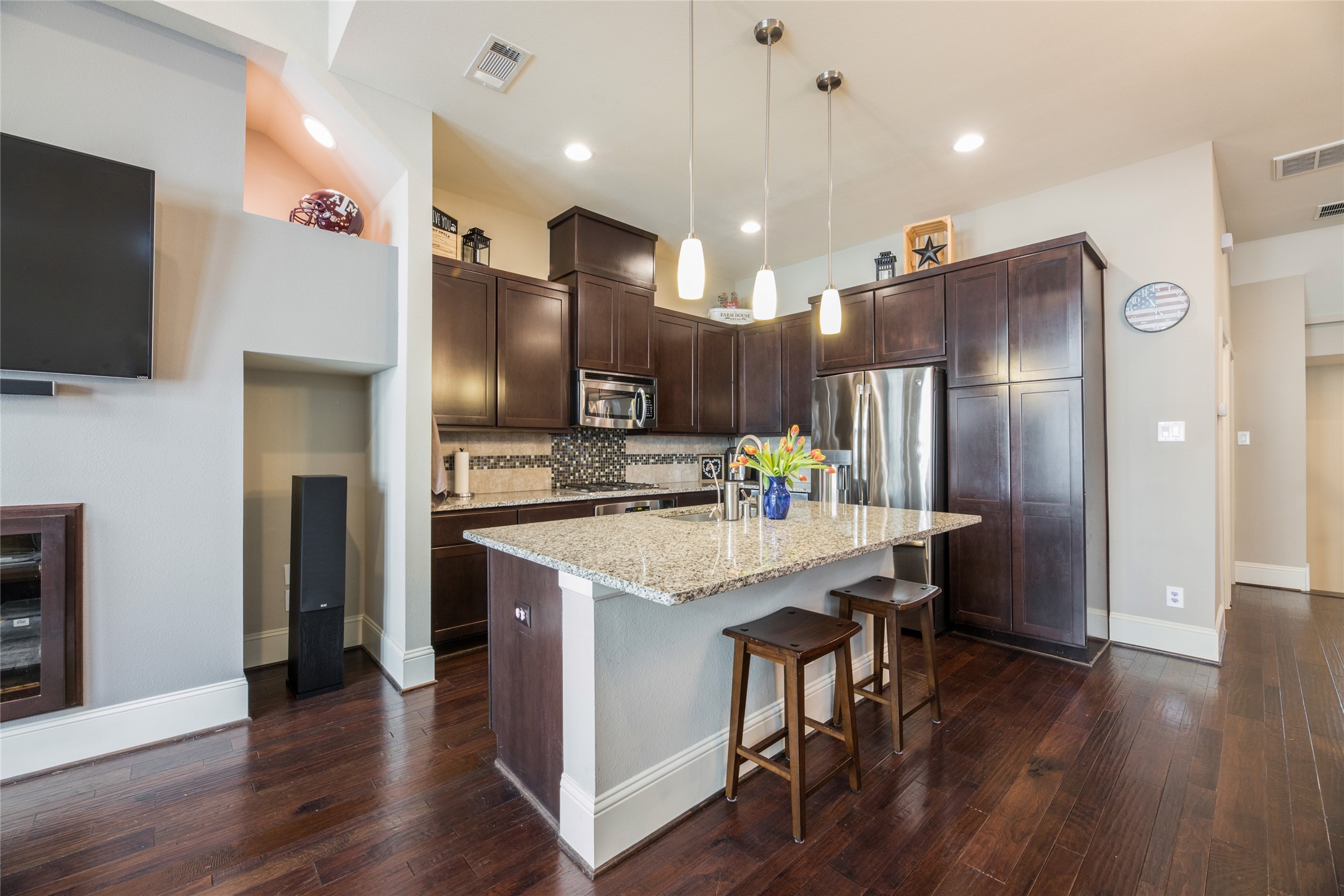 769 Waverly Street Houston, TX 77007 - Photo 11 of 35 a kitchen with stainless steel appliances kitchen island granite countertop a refrigerator a stove a microwave oven a sink with island and chairs