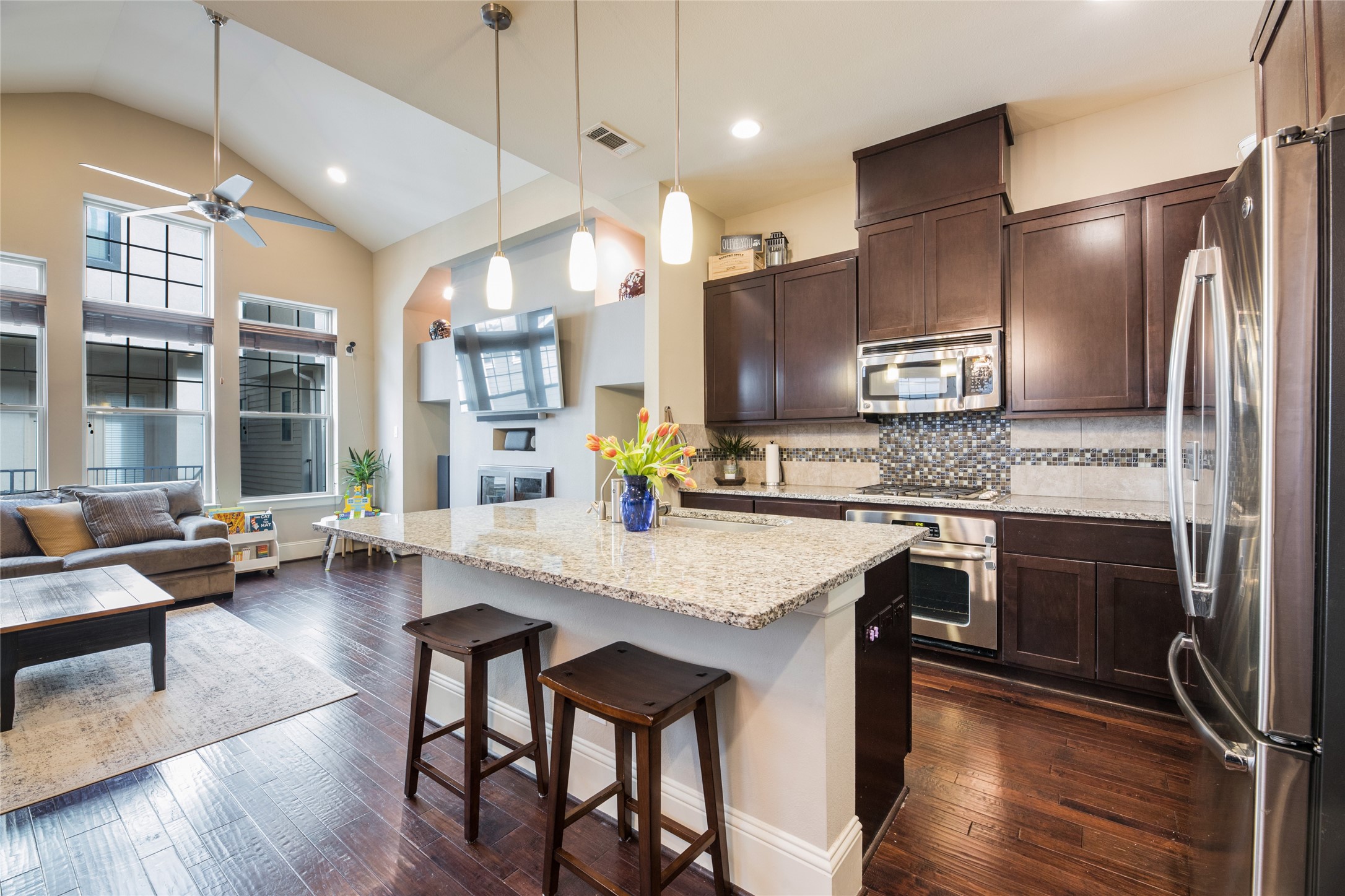 769 Waverly Street Houston, TX 77007 - Photo 12 of 35 a kitchen with stainless steel appliances granite countertop wooden floor a stove a sink a refrigerator and chairs