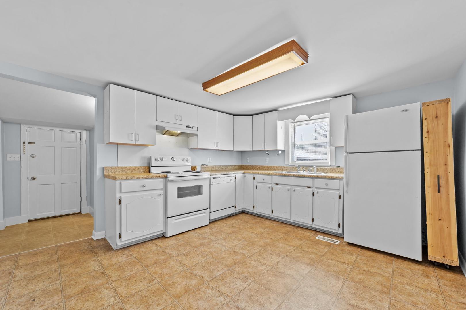 2005 Doc Nichols Road Durham, NC 27703 - Photo 28 of 37 a kitchen with a refrigerator and white cabinets