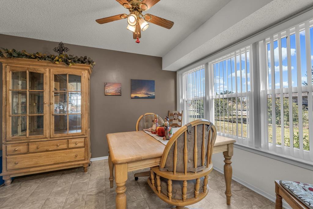 107 Fort Graham Circle Waco, TX 76705 - Photo 17 of 39 Dining space featuring a ceiling fan and a textured ceiling