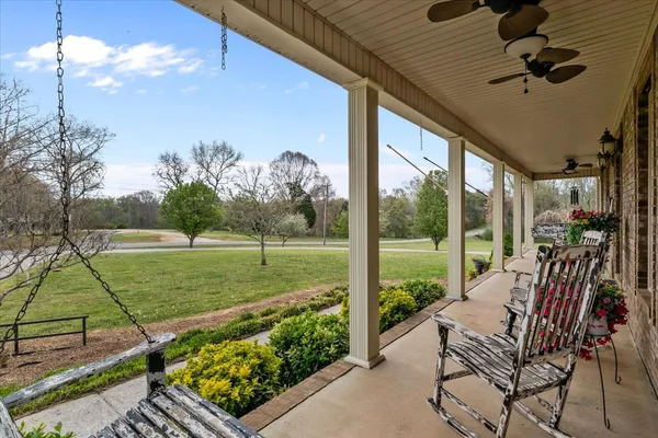a view of a porch with furniture and a yard