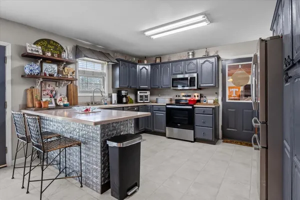 a kitchen with stainless steel appliances granite countertop a stove top oven a sink and dishwasher