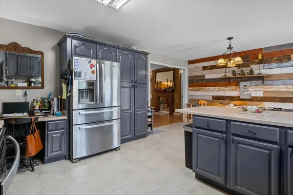 a kitchen with stainless steel appliances granite countertop a refrigerator and a stove top oven