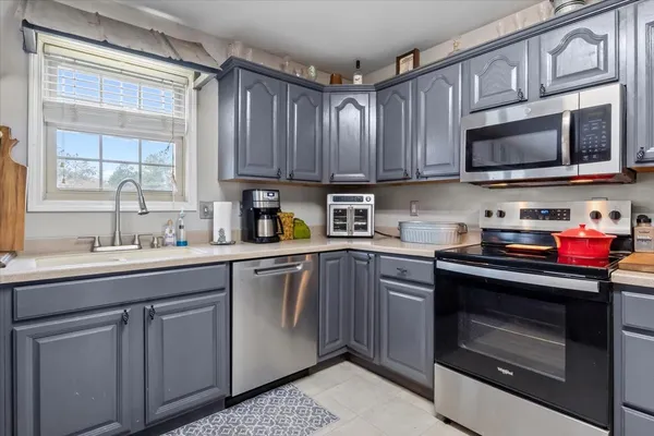 a kitchen with stainless steel appliances granite countertop a sink dishwasher a stove and a microwave oven with cabinets