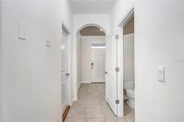 a view of a hallway with wooden floor and a bathroom