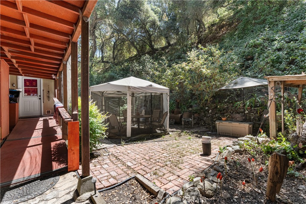 1010-1012 Upper Los Berros Road Nipomo, CA 93444 - Photo 66 of 75 a view of a patio with table and chairs under an umbrella with a fire pit