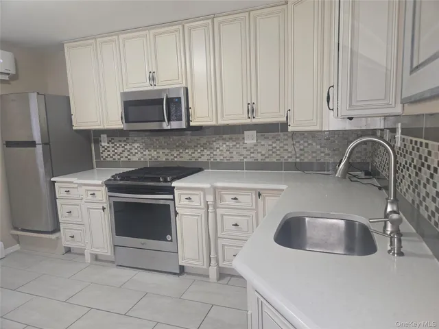 a kitchen with granite countertop a sink stove and refrigerator
