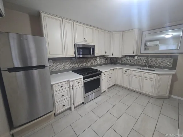 a kitchen with white cabinets stainless steel appliances and a sink