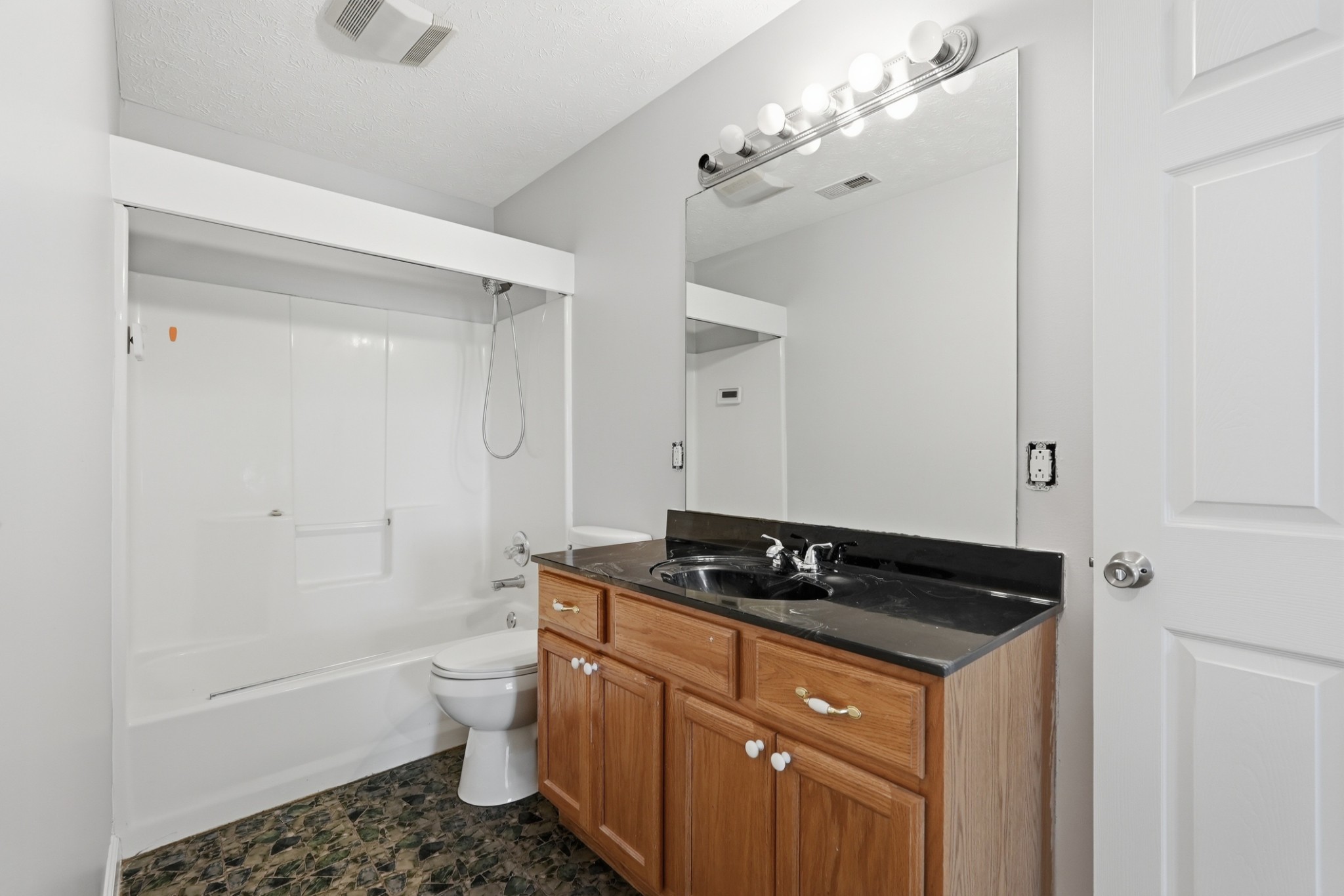 4877 Swafford Road Cookeville, TN 38501 - Photo 21 of 28 a bathroom with a granite countertop sink a toilet a mirror and shower