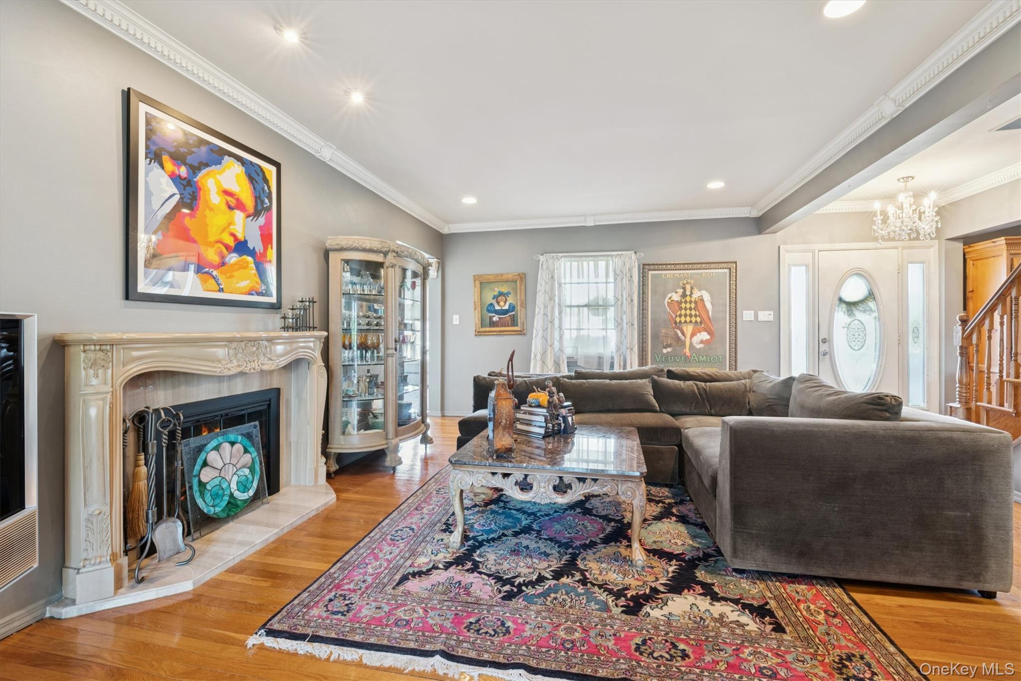 52-11 Redfield Street Queens, NY 11362 - Photo 11 of 32 Living room featuring ornamental molding, light wood-style flooring, a fireplace with raised hearth, recessed lighting, and a chandelier