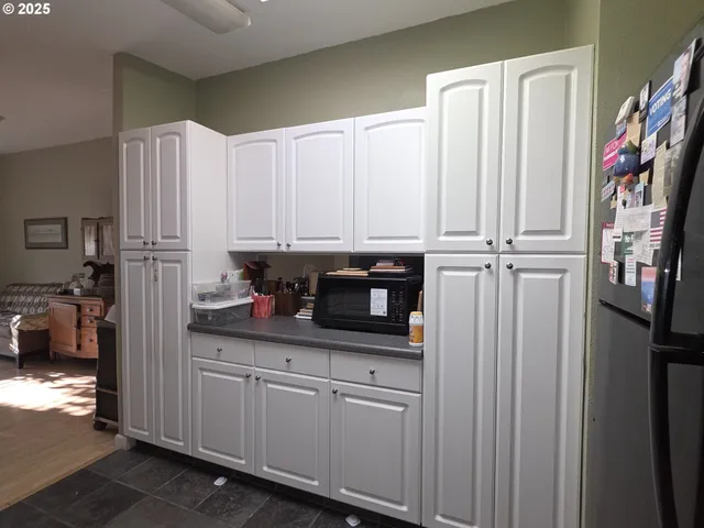 a kitchen with stainless steel appliances granite countertop white cabinets a stove a microwave and a sink