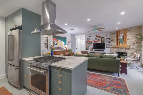 a kitchen with stainless steel appliances granite countertop a stove refrigerator and a microwave