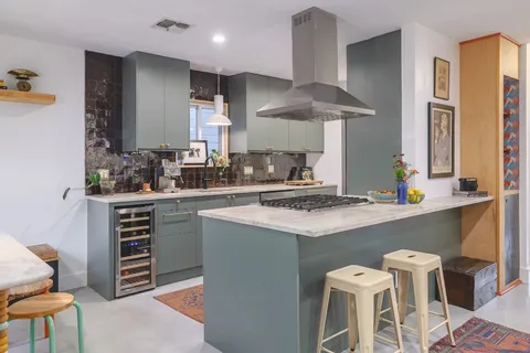 a kitchen with stainless steel appliances a stove a sink and a refrigerator
